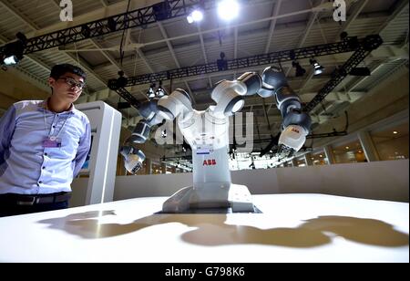 Tianjin, China. 26th June, 2016. A visitor views a collaborative robot at the exploration zone on the Annual Meeting of the New Champions 2016, or the Summer Davos Forum, in Tianjin, north China, June 26, 2016. © Yue Yuewei/Xinhua/Alamy Live News Stock Photo