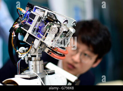 Tianjin, China. 26th June, 2016. A staff member operates a robot at the exploration zone on the Annual Meeting of the New Champions 2016, or the Summer Davos Forum, in Tianjin, north China, June 26, 2016. © Yue Yuewei/Xinhua/Alamy Live News Stock Photo