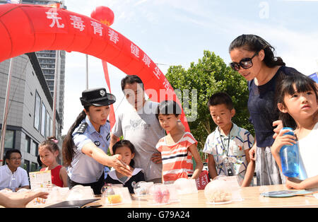 Liaocheng, China's Shandong Province. 26th June, 2016. A policewoman introduces harm of drug to children in Liaocheng, east China's Shandong Province, June 26, 2016. A variety of educational activities were held across the country on Sunday, the International Day against Drug Abuse and Illicit Trafficking. © Fu Yantao/Xinhua/Alamy Live News Stock Photo