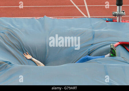 Pole vault athlete falls onto the crash mat during Stock Photo