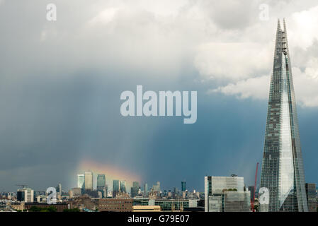 London, United Kingdom - June 25, 2016: Incredible lighting effect over Canary Wharf. Rainbow in stormy sky, with Shard in the front Credit:  Elena Chaykina/Alamy Live News Stock Photo