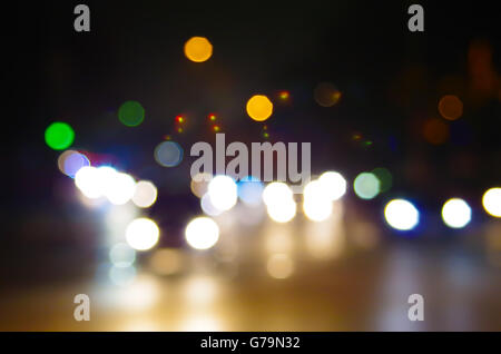 Abstract blurred night scene on city road. Defocused lights from the headlights of cars and the night lights of a city street. Stock Photo