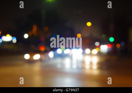Abstract blurry spots of light in the night city street scene with reflections of neon lights and headlights Stock Photo
