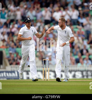 England's Stuart Broad (right) celebrates with captain Alastair Cook after taking the final wicket fo India's MS Dhoni (not pictured) during day one of the Fifth Test at The Kia Oval, London. Stock Photo