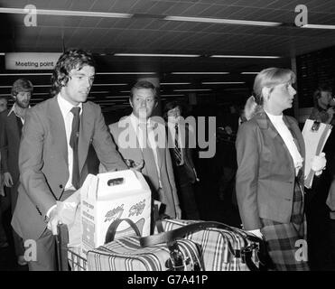 Manchester United's Joe Jordan (left) with his luggage at london's Gatwick airport when he and other members of the Scottish World Cup squad returned home from their troubled time in Argentina where their World Cup hopes were shattered in the first round. Stock Photo