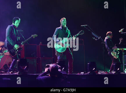Josh Homme (centre) of Queens of the Stone Age performing on the Main Stage, at the Reading Festival, at Little John's Farm on Richfield Avenue, Reading. Stock Photo