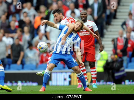 Brighton and Hove Albion's Craig Mackail-Smith (front) and Charlton Athletic's Johnnie Jackson battle for the ball during the Sky Bet Championship match at the AMEX Stadium, Brighton. Stock Photo