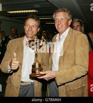 Colin Montgomerie (right) and non-playing captain Bernhard Langer with the Ryder Cup as the victorious European Ryder Cup Team arrive at Heathrow Airport, London. They completed their win by a record margin of 18.5 to 9.5 over the American team at Oakland Hills, Detroit, Sunday, after Scot, Colin Montgomerie sank the winning putt to bring the trophy back to Europe. Stock Photo