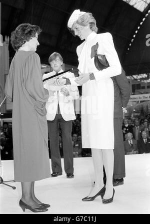The Princess of Wales, wearing a dress by designer Bruce Oldfield, presenting a prize in the holiday poster competition to Austria, during the World Travel Market at Olympia in London. The Princess had earlier officially opened the market, which is the travel industry's top trade exhibition. Stock Photo