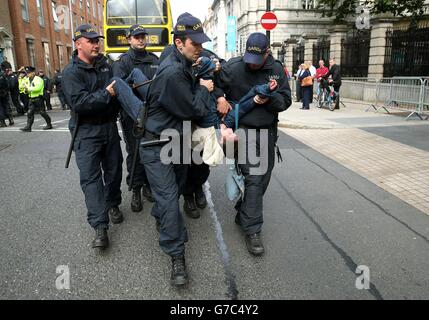 A protester is moved by members of the Garda as demonstrators gathered ...