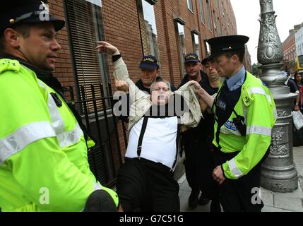 A protester is moved by members of the Garda as demonstrators gathered ...