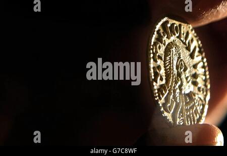 A Spinks employee displays an Anglo-Saxon penny at their auction house in central London. The coin, found by an amateur metal detectionist in Bedfordshire, can be dated to around the 9th century, and is expected to fetch between 120,000 and 150,000. 06/10/04: The Anglo-Saxon penny fetched 230,000 at auction Wednesday 6 October 2004 - breaking the world record for a British coin. Specialists at Spink auction house in London had expected it to fetch between 120,000 and 150,000. Stock Photo