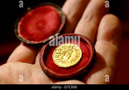 A Spinks employee displays an Anglo-Saxon penny at their auction house in central London. The coin, found by an amateur metal detectionist in Bedfordshire, can be dated to around the 9th century, and is expected to fetch between 120,000 and 150,000. Stock Photo