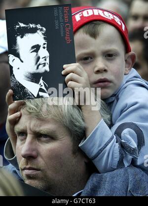 A young Nottingham Forest fan on the shoulders of his father watching the memorial sevice to legendary football manager Brian Clough in the Old Market Square, Nottingham. Former players and dignataries gathered at the public event which is the first of many tributes to Clough, who died of stomach cancer on Monday aged 69. It will be followed by a minute's silence at Nottingham Forest's City Ground, ahead of the club's match against West Ham. Stock Photo