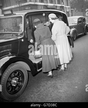 Princess Alexandra of Kent (r) and an unidentified friend paying off a taxicab on arrival at Marlborough House, London, to see the Princess' grandmother, Queen Mary, whose condition is causing increasing anxiety. Stock Photo