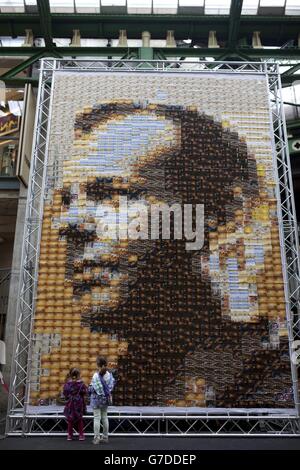 Passers-by look at a 24 metre square canvas, made from 1,485 postcards of actor Kiefer Sutherland in character as Jack Bauer from television drama 24, on display at Borough Market in London which was used as a filming location to mark the Blu-ray and DVD release of 24: Live Another Day on Monday October 6. Stock Photo