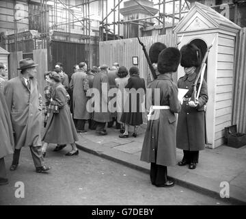 The crowd reading the first bulletin, which discloses Queen Mary's health is deteriorating, outside Marlborough House in London. Queen Mary, who is 85, has been ill for some weeks with a recurrence of gastric trouble. It reads: ' Queen Mary had a restless night due to a sudden occurrence of more severe symptoms of gastric trouble. Her Majesty's condition is causing some anxiety.'. Stock Photo