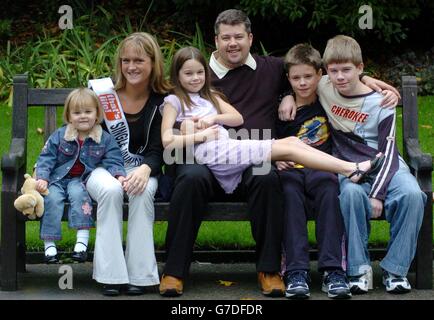 Annmarie Fraser (2nd left), 19, from Aberdeen, sits with her daughter Megan, 2, and Lee Grindley, 37, from Shrewsbury, with his children Stefan (right),14, Ashley, 12, and Felicia, 11, as they celebrate being awarded the 'That's Life! Single Mum and Single Dad of the Year 2004', at an awards reception held at The Savoy in central London. Annmarie was just 16, pregnant and living in a council bed-sit for the homeless. But three years on, she has a job, a home, helps other people in trouble and is planning to start a degree course. Lee's story is one of tragedy as he watched his wife and Stock Photo