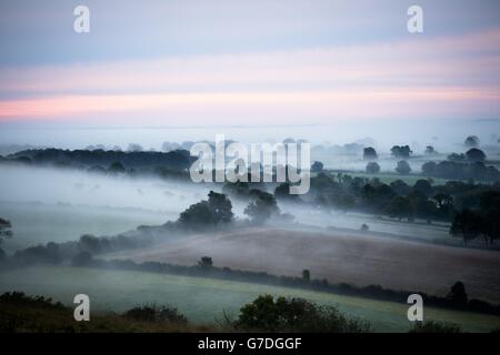 Mist rolls in over the Somerset Levels at sunrise as Autumn takes hold and the mornings become darker and colder across the UK. Stock Photo