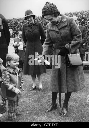 Queen Elizabeth II receives a posy from two-year-old Roddy Black from Woking during a visit to the Royal Horticultural Society's Garden at Wisley. Stock Photo
