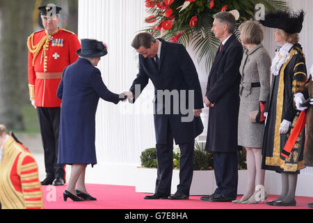 Queen Elizabeth II (left) shakes hands with British Prime Minister David Cameron as Foreign Secretary Philip Hammond (third right) and Home Secretary Theresa May (second right) stand by as they attend the ceremonial welcome ceremony for Singapore's President Tony Tan Keng Yam at the start of a state visit at Horse Guards Parade in London. Stock Photo