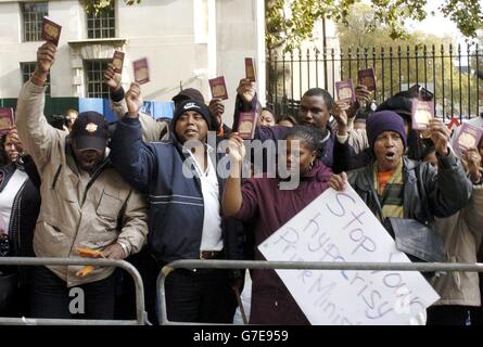Exiled residents of the Indian Ocean island of Diego Garcia demonstrate opposite Downing Street, central London. Up to 80 homeless Diego Garcian exiles gathered at Downing Street to call for Britain to house them or return them home. Waving their British passports in the air, they chanted: 'Tony Blair is a thief. Give us our islands back.' Stock Photo