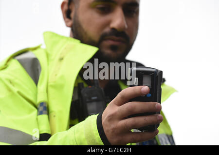 A police officer checks a drivers fingerprints on a mobile identification device Stock Photo