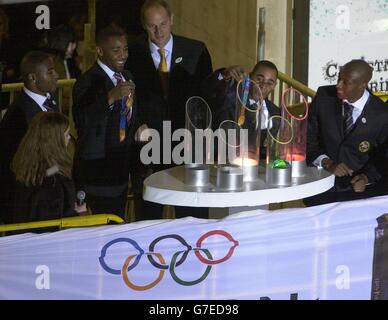 Teenage actress Emma Watson, who plays Hermione Grainger in the Harry Potter films, helps Olympic gold medal winners (l to r) Mark Lewis-Francis, Darren Campbell, Sir Steve Redgrave, Jason Gardner and Marlon Devonish, to turn on the traditional Christmas lights in London's Oxford Street Stock Photo