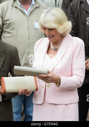 The Duchess of Cornwall is presented with a a clutch bag by teacher Magly Palacios during a visit to Escuela de Artes Y Oficios Arts and Crafts School, Bogota, Colombia, on the second day of the Prince of Wales and Duchess of Cornwall's tour to Colombia and Mexico. Stock Photo