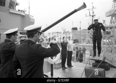 Exchange of salutes as the Duke of Edinburgh is piped aboard the 360-ton minehunter HMS Bronington to be welcomed by the captain, Lieutenant Prince Charles (foreground). The Duke, in Admiral of the Fleet's uniform, was paying an informal visit to the ship - the Prince's first command - at Rosyth naval base. Stock Photo