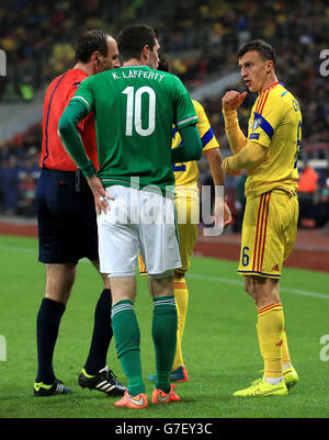 Northern Ireland's Kyle Lafferty (left) argues with Romania's Vlad Chiriches during the UEFA Euro 2016 qualifier at the Arena Nationala, Bucharest. Stock Photo