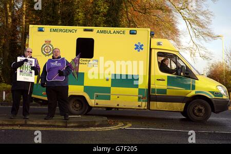 An ambulance drives past NHS health workers outside the Basingstoke and North Hampshire Hospital in Basingstoke, as they protest at the Coalition's controversial decision not to accept a recommended 1% wage rise for all NHS employees. Stock Photo