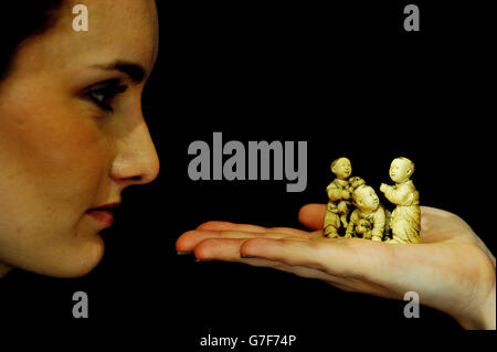 Bonhams visitor Lauren Hurley looks at an okimono (decorative object) ivory group figurine, during a preview for the forthcoming Fine Japanese Art Sale at Bonhams in central London. Stock Photo