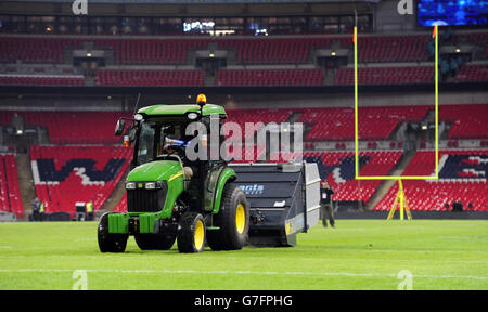 Groundsmen cut the grass on the pitch after the NFL International match at Wembley Stadium, London. Picture date: Sunday November 9, 2014. See PA story GRIDIRON NFL. Photo credit should read: Andrew Matthews/PA Wire. RESTRICTIONS: News and Editorial use only. Commercial/Non-Editorial use requires prior written permission from the NFL. Digital use subject to reasonable number restriction and no video simulation of game. For further info please call +44 (0)115 8447447. Stock Photo