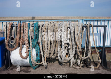 Anchor ropes, mooring lines, old, aged, weathered marine equipment in port, hangout to dry Stock Photo