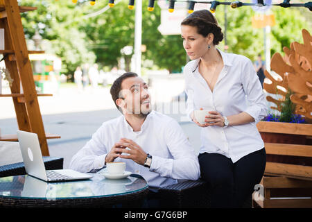 Business Team man and woman at Cafe having a conversation using laptop. Working Meeting Concept Stock Photo