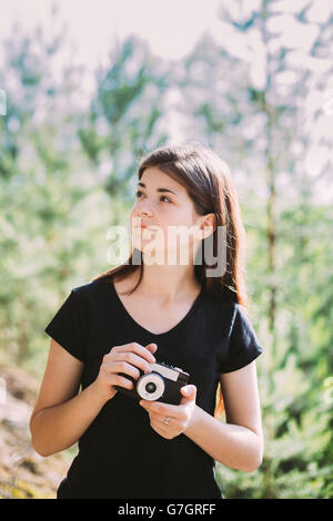 Happy Red-haired Caucasian Girl Young Woman Photographer Taking Pictures The Old Retro Vintage Film Camera In Summer Green Fores Stock Photo