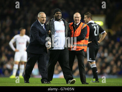 A pitch invader is escorted off the pitch by security during the UEFA Europa League match at White Hart Lane, London. PRESS ASSOCIATION Photo. Picture date: Thursday November 27, 2014. See PA story SOCCER Tottenham. Photo credit should read: Nick Potts/PA Wire. Stock Photo