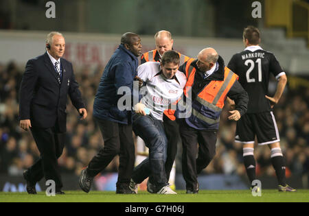 A third pitch invader is escorted off the pitch by security during the UEFA Europa League match at White Hart Lane, London. PRESS ASSOCIATION Photo. Picture date: Thursday November 27, 2014. See PA story SOCCER Tottenham. Photo credit should read: Nick Potts/PA Wire. Stock Photo