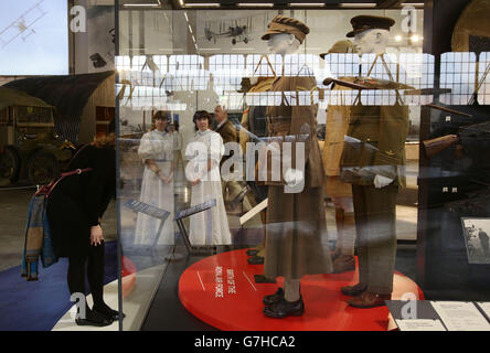 Visitors looking a display of vintage uniforms on show, during a preview of the Royal Air Force Museum's The First World War in the Air exhibition, at the Royal Air Force Museum in London. Stock Photo