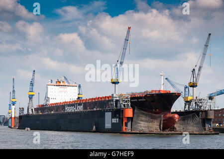 Container ship undergoing repairs in dry dock at  Port of Hamburg on River Elbe in Germany Stock Photo