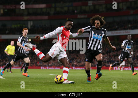 Arsenal's Danny Welbeck has a shot on goal under pressure from Newcastle United's Fabricio Coloccini (right) during the Barclays Premier League match at the Emirates Stadium, London. Stock Photo