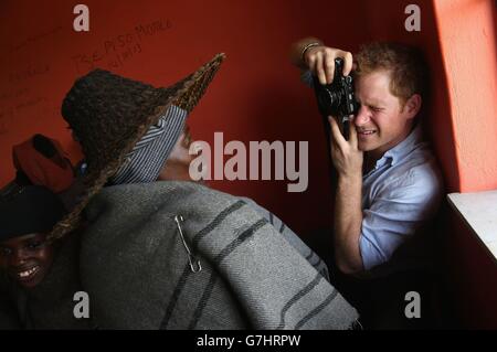 Prince Harry takes a photograph on a Fuji X100s Camera during a visit to a herd boy night school constructed by Sentebale in Mokhotlong, Lesotho. Stock Photo