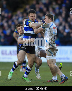 Bath Rugby's Sam Burgess is tackled by Exeter Chiefs Henry Slade (left) and Sam Hill (right) during the Aviva Premiership match at the Recreation Ground, Bath. Stock Photo