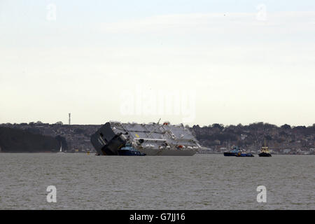 The car carrier Hoegh Osaka near Lee-on-the-Solent, Hampshire, is towed to a holding position after it re-floated on the high tide. Stock Photo