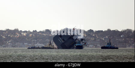 The car carrier Hoegh Osaka near Lee-on-the-Solent, Hampshire, is towed to a holding position after it re-floated on the high tide. Stock Photo