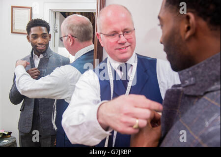 London Collections: Men Ambassador Tinie Tempah has a final fitting with head cutter Stephen Allen at Savile Row tailors, Norton and Sons in London, for a bespoke suit made from specially commissioned London Tweed designed by the Museum of London, ahead of the Autumn/Winter 2015 menswear fashion shows &ETH; which begins on Friday 9 January. Stock Photo