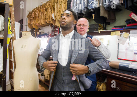 London Collections: Men Ambassador Tinie Tempah has a final fitting with head cutter Stephen Allen at Savile Row tailors, Norton and Sons in London, for a bespoke suit made from specially commissioned London Tweed designed by the Museum of London, ahead of the Autumn/Winter 2015 menswear fashion shows &ETH; which begins on Friday 9 January. Stock Photo