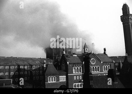 Smoke billows from the roof of Strangeways prison in Manchester after inmates set fire to debris piled inside. Stock Photo