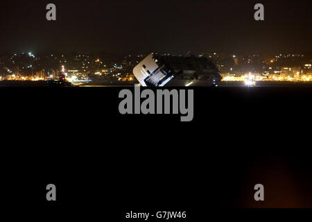 The car carrier Hoegh Osaka near Lee-on-the-Solent as it is being towed to a holding position after it was refloated on the high tide after it was beached on Bramble Bank near to Southampton, Hampshire. Stock Photo